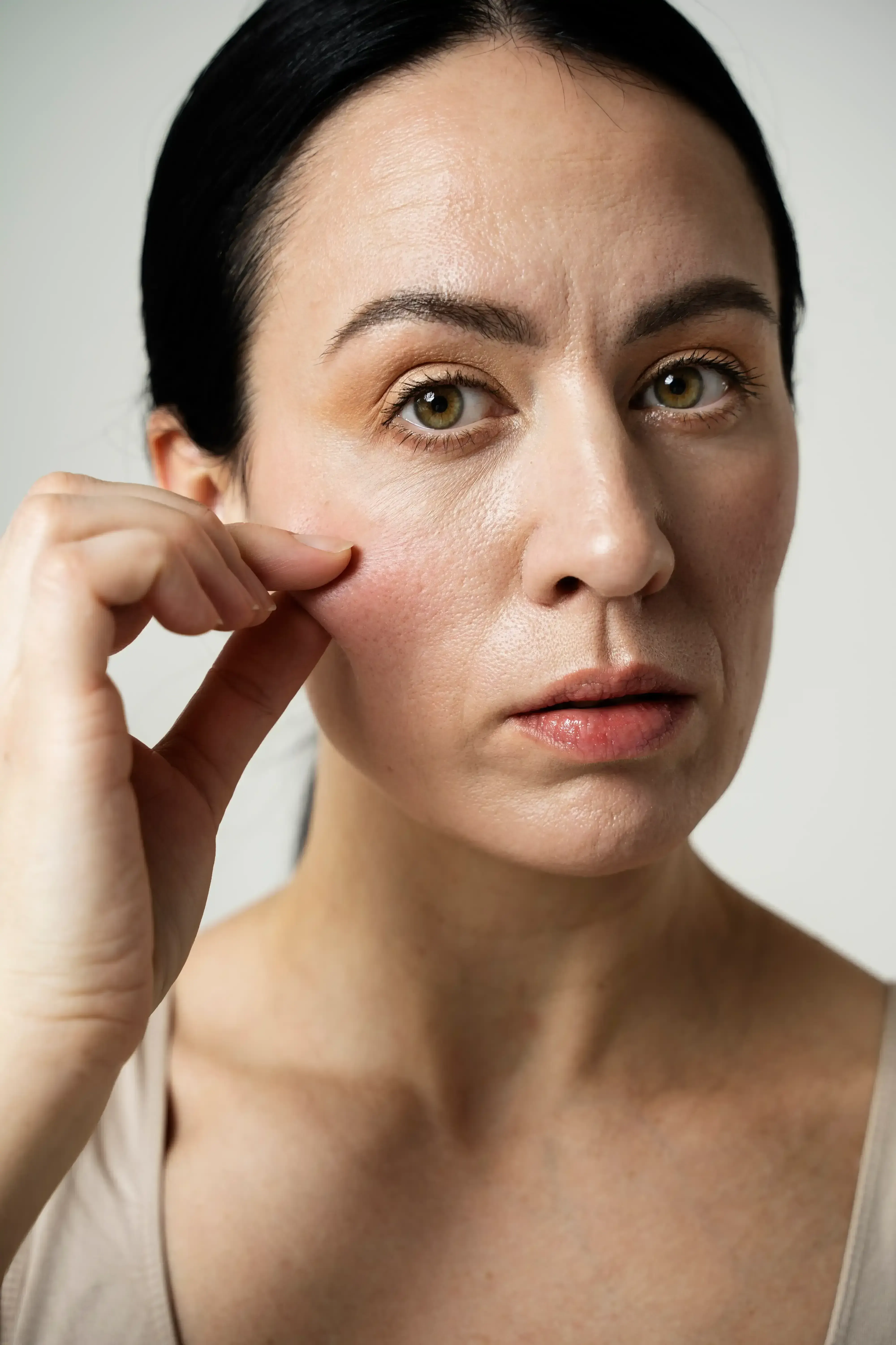 Woman noticing flattened cheeks and considering cheek filler at Healthy Enhancements