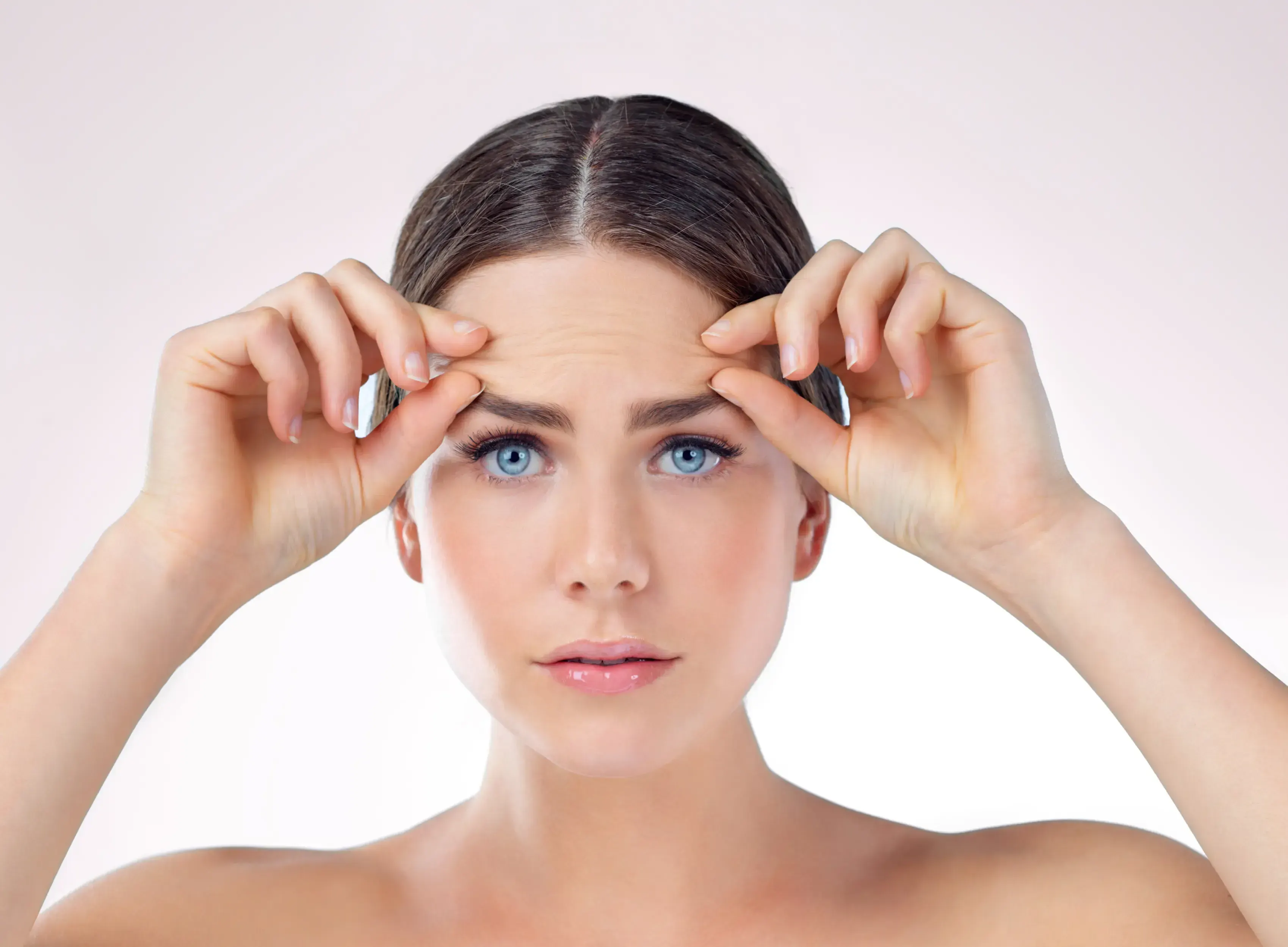 Woman noticing horizontal forehead lines in the mirror at Healthy Enhancements Wellington